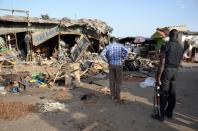 A police officer in northeastern Nigeria at the scene of a suicide bombing after at least 20 people were killed when a young female detonated explosives at a bus station on June 22, 2015