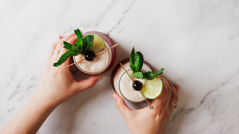 Hands serving two mocktails