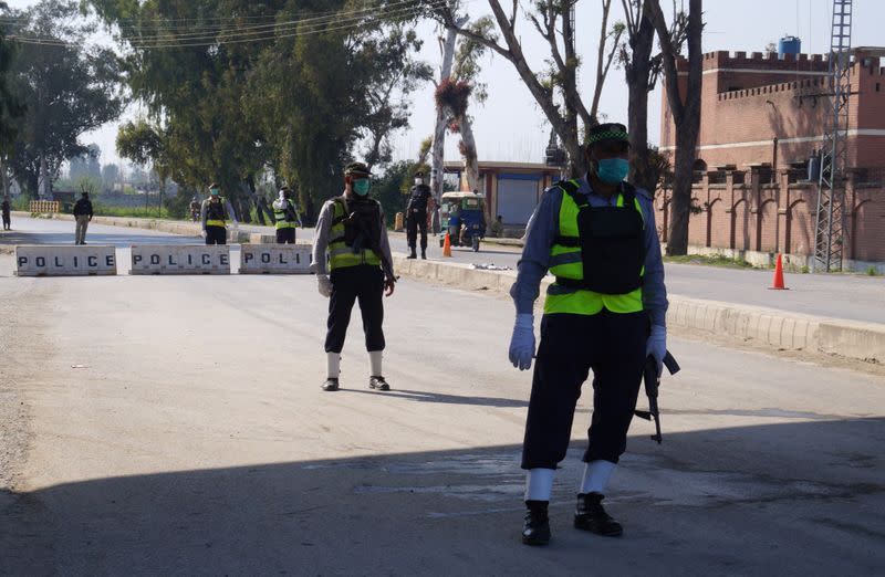 Police officers stand guard at a blocked road leading to Manga village after an outbreak of coronavirus disease (COVID-19), in Marden