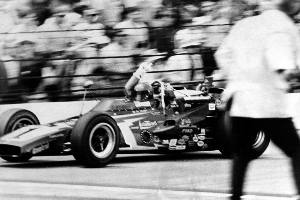 FILE - Al Unser, the defending champion, waves his arm in salute as he takes the checkered flag in his Johnny Lightning Special to win the 55th running of the Indy 500-mile race at the Indianapolis Motor Speedway in Indianapolis, Ind., Saturday, May 29, 1971. Unser, one of only four drivers to win the Indianapolis 500 a record four times, died Thursday, Dec. 9, 2021, following years of health issues. He was 82. (AP Photo, File)