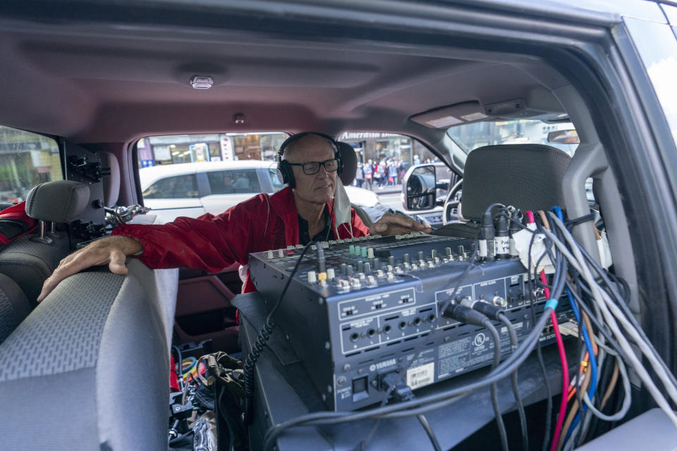 Lawrence Rock, director de sonido de la Filarmónica de Nueva York, trabaja en la camioneta mientras el contratenor y productor Anthony Roth Costanzo actúa en el barrio de Flushing en Queens, Nueva York, el viernes 2 de octubre de 2020. El equipo hizo tres conciertos no anunciados en rincones de la ciudad de Nueva York entre el viernes y el domingo, ofreciendo música de cámara dentro de las actividades de otoño de la orquesta. (AP Foto/Mary Altaffer)