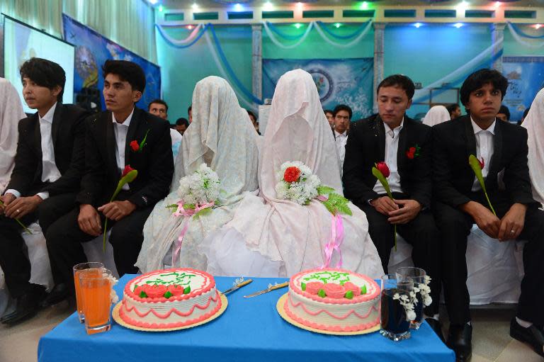 Afghan couples look on during a mass wedding ceremony in which 100 couples were married near Kabul, October 10, 2014