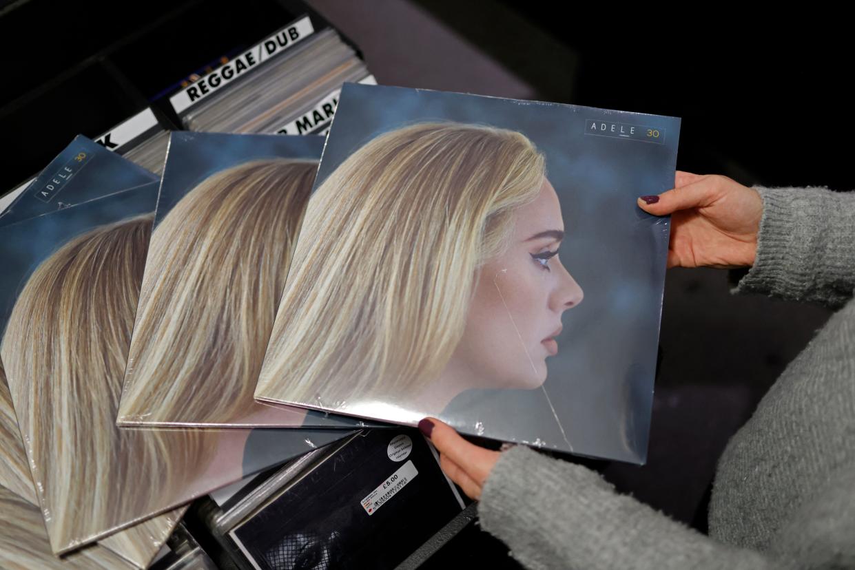 A member of staff sorts copies of the new album from British singer-songwriter Adele, 