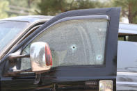 In this Saturday, June 19, 2021, photo courtesy of The White Mountain Independent is a damaged pickup truck which ran over a group of cyclists in Show Low, Ariz. Police say a driver in the pickup truck plowed into bicyclists competing in a community road race in Arizona, critically injuring several riders. Authorities say officers then chased down the driver Saturday and shot him outside a nearby hardware store. (Jim Headley/The White Mountain Independent via AP)