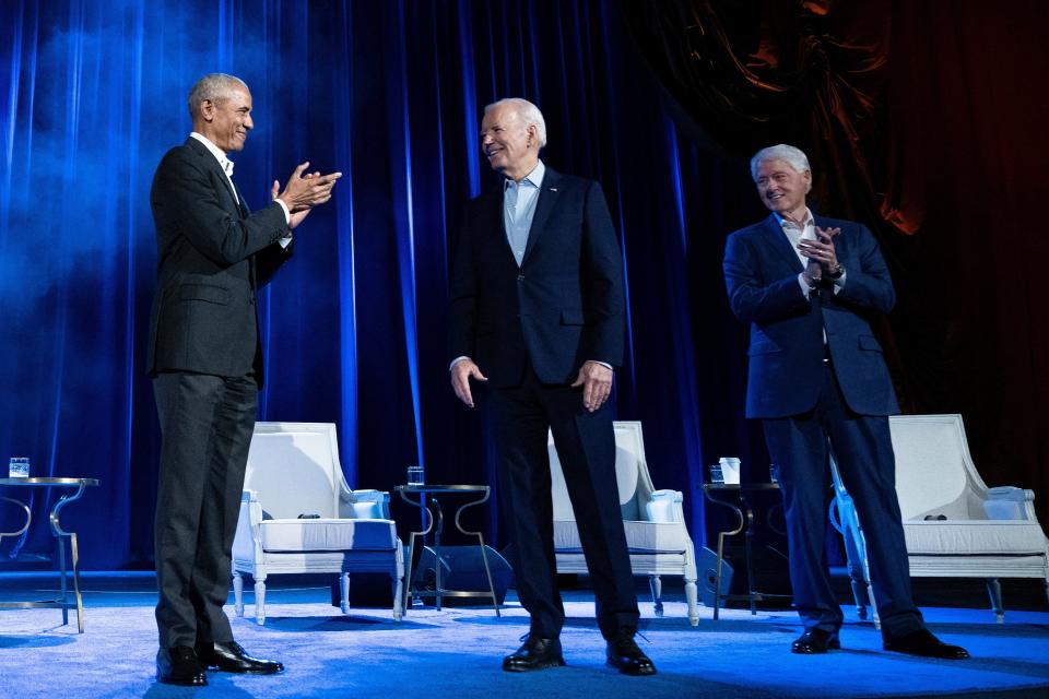 President Barack Obama (L) and former US President Bill Clinton (R) clap for US President Joe Biden during a campaign fundraising event at Radio City Music Hall in New York City on March 28, 2024.