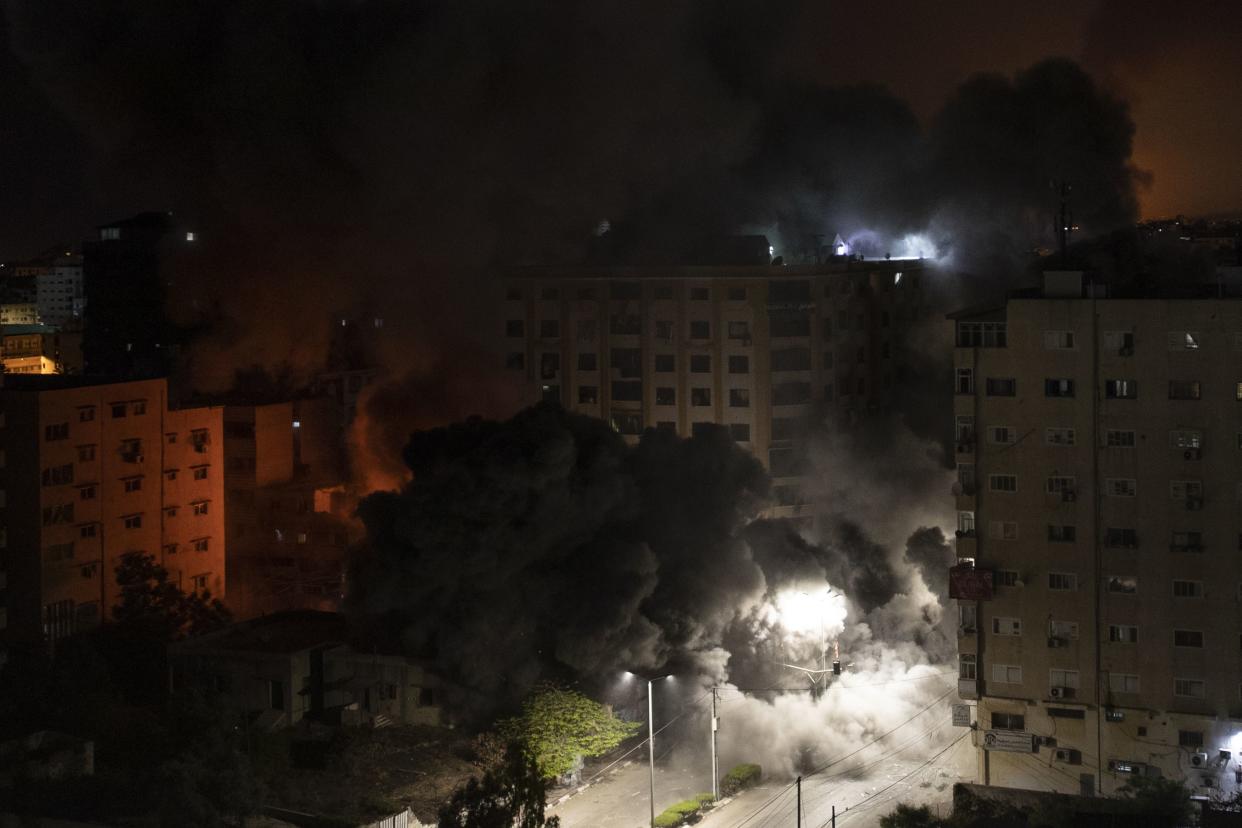 Smoke caused by Israeli airstrikes is seen on a residential building in Gaza City, early Wednesday, May 12, 2021.