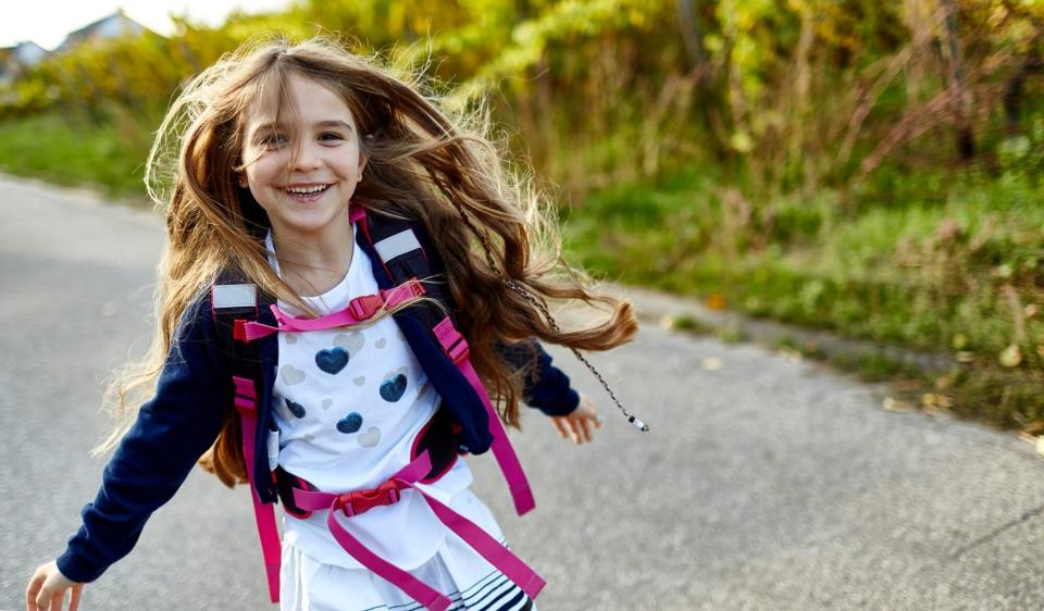 An image of a little girl with a backpack on.