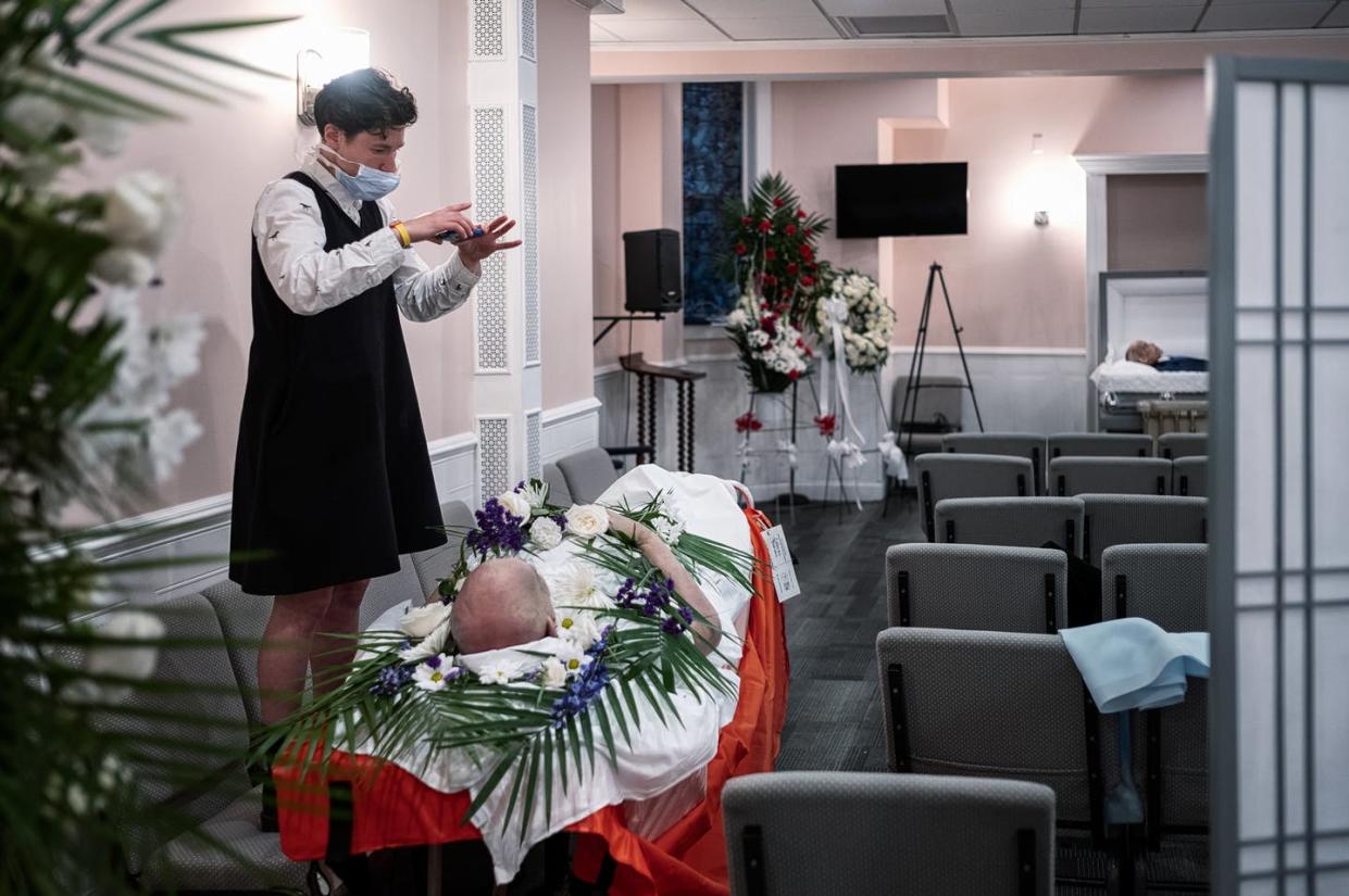 <span class="caption">A funeral director calls relatives of a COVID-19 victim for a virtual viewing before cremation on May 22, 2020 in New York City. </span> <span class="attribution"><a class="link " href="https://www.gettyimages.com/detail/news-photo/lily-sage-weinrieb-calls-relatives-of-a-covid-victim-for-a-news-photo/1214854208?adppopup=true" rel="nofollow noopener" target="_blank" data-ylk="slk:Misha Friedman/Getty Images;elm:context_link;itc:0;sec:content-canvas">Misha Friedman/Getty Images</a></span>
