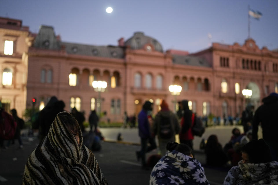 La gente usa mantas en medio del frío afuera de la casa de gobierno durante una protesta de organizaciones sociales para exigir más subsidios gubernamentales para los pobres en medio de la alta inflación en Buenos Aires, Argentina, el miércoles 10 de agosto de 2022. (AP Foto/Natacha Pisarenko)