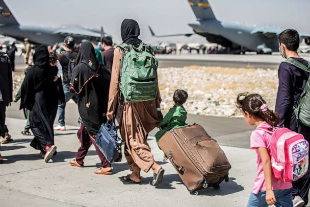 PHOTO: In this Aug. 24, 2021, file photo, provided by the U.S. Marine Corps, families walk towards their flight during ongoing evacuations at Hamid Karzai International Airport, in Kabul, Afghanistan. (Sgt. Samuel Ruiz/U.S. Marine Corps via AP, FILE)