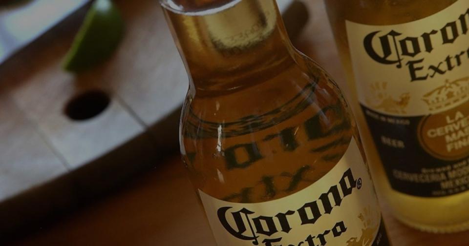 Two Corona Extra beer bottles with out-of-focus background.