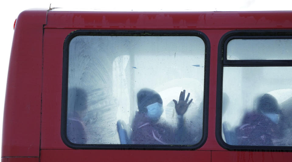 A group of people thought to be migrants wait on a holding bus after being brought in to Dover, Kent, England, Thursday, Nov. 25, 2021. On Wednesday around 30 migrants bound for Britain died when their boat sank in the English Channel, in what France’s interior minister called the biggest migration tragedy on the dangerous crossing to date. (Gareth Fuller/PA via AP)