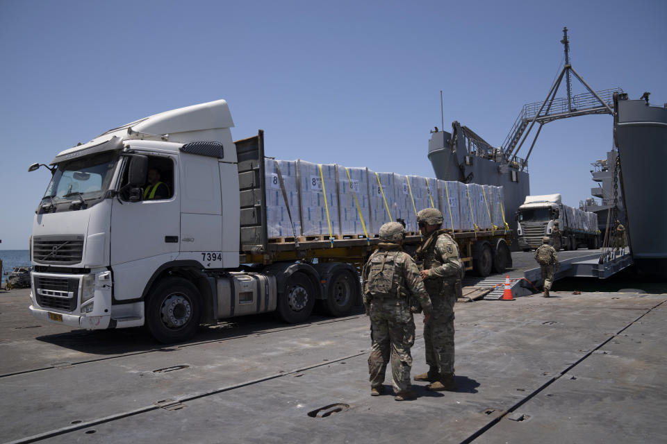 U.S. Army soldiers stand next to trucks arriving loaded with humanitarian aid at the U.S.-built floating pier Trident before reaching the beach on the coast of the Gaza Strip, Tuesday, June 25, 2024. (AP Photo/Leo Correa)