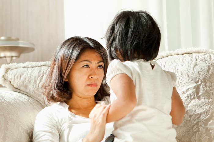 Woman and child in a serious conversation, seated indoors, possibly discussing child’s behavior or concerns