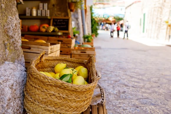 Ripe lemons in a wicker basket for sale in a sunny Italian village.