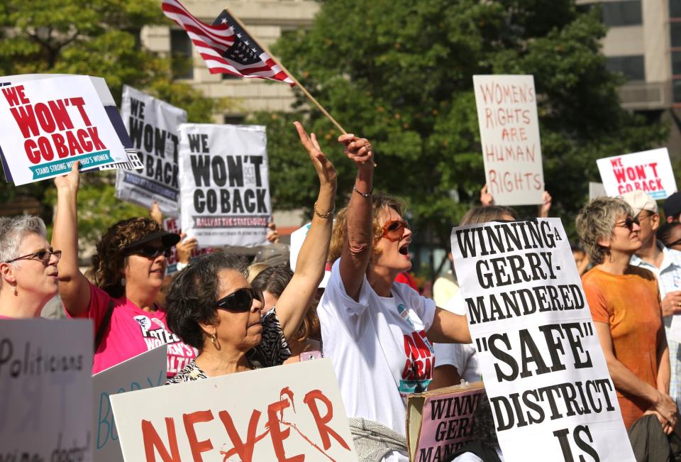 Ruth Clevenger waves an American flag during a protest at the Ohio Statehouse in Columbus in 2013. The rally was organized to draw attention to legislation that will affect Ohio laws dealing with women's health care.