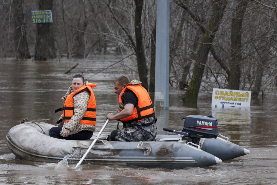 A rescuer transfers a woman using a boat in a flooded area in Orenburg, Russia, Wednesday, April 10, 2024. Russian officials are scrambling to help homeowners displaced by floods, as water levels have risen in the Ural River. The floods in the Orenburg region near Russia's border with Kazakhstan sparked the evacuation of thousands of people following the collapse of a dam on Saturday. (AP Photo)