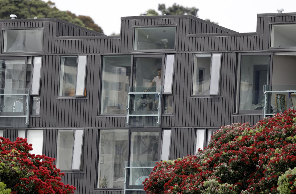 A resident watches play on day one of the first cricket test between New Zealand and Sri Lanka from his apartment window in Wellington, New Zealand, Saturday, Dec. 15, 2018. (AP Photo/Mark Baker )