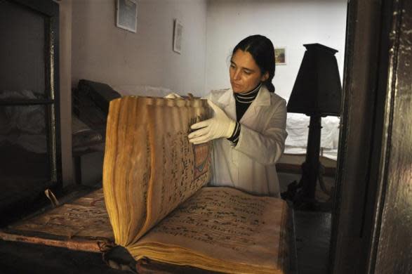 Director of Descalzos Foundation Alberta Alvarez reviews a choral book at a storage room at the Franciscan convent Los Descalzos in Lima, May 24, 2012.