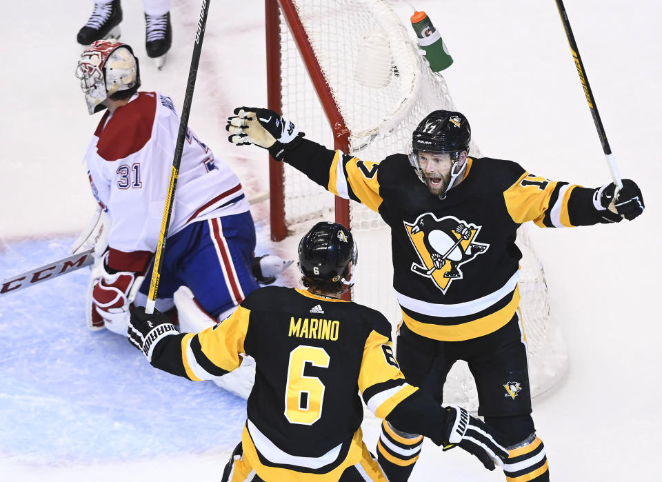 Pittsburgh Penguins right wing Bryan Rust (17) celebrates his goal with defenseman John Marino (6) as Montreal Canadiens goaltender Carey Price (31) kneels near the net during the second period of an NHL hockey playoff game in Toronto, Saturday, Aug. 1, 2020. (Nathan Denette/The Canadian Press via AP)