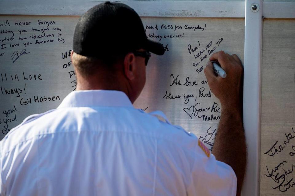 Messages are written on the back of the Paul Vincent Rotondaro Memorial Highway sign during a dedication ceremony near Gustine, in Merced County, Calif., on Monday, Sept. 18, 2023. Cal Fire Capt. Paul Rotondaro was killed in a traffic collision while on duty in Merced County on Oct. 2, 2019.