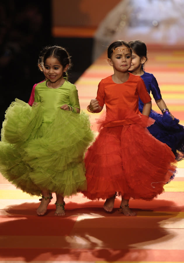 <b>Jean Paul Gaultier SS13 </b><br><br>These miniature models donned gowns in bright orange, lime green and navy blue shades teamed with embellished sandals.<br><br>© Rex