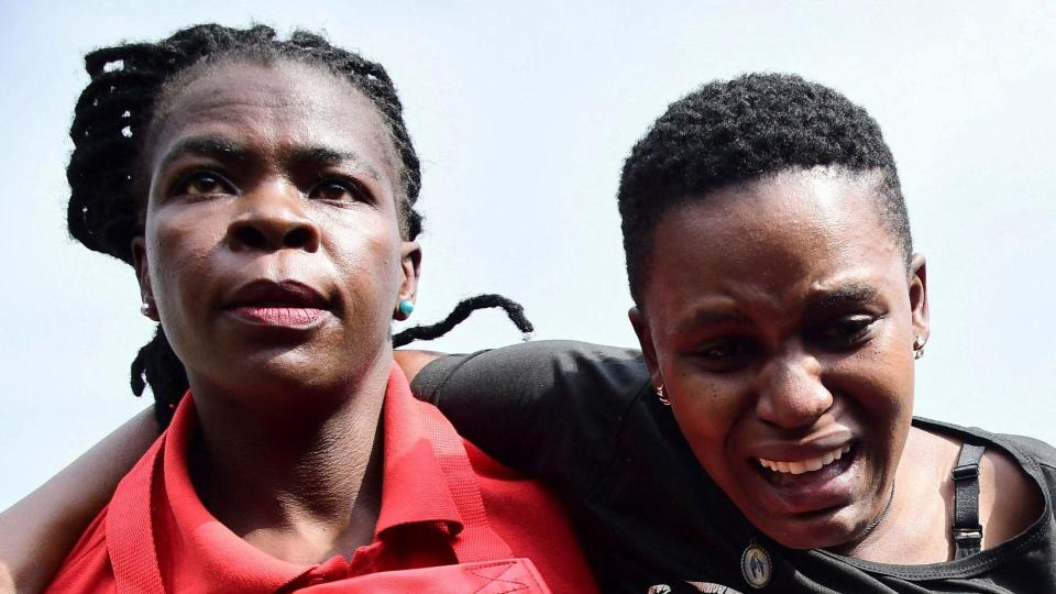 A distraught woman is helped by a member of the Uganda Kampala Red Cross, near Kampala, Uganda, August 10, 2024