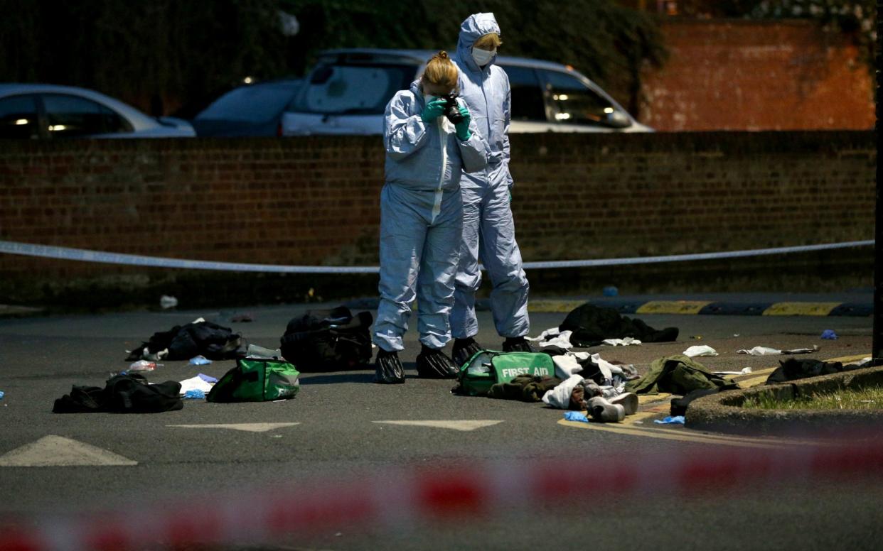 Forensics officers inspect the area outside Landor House, Camberwell, London - PA