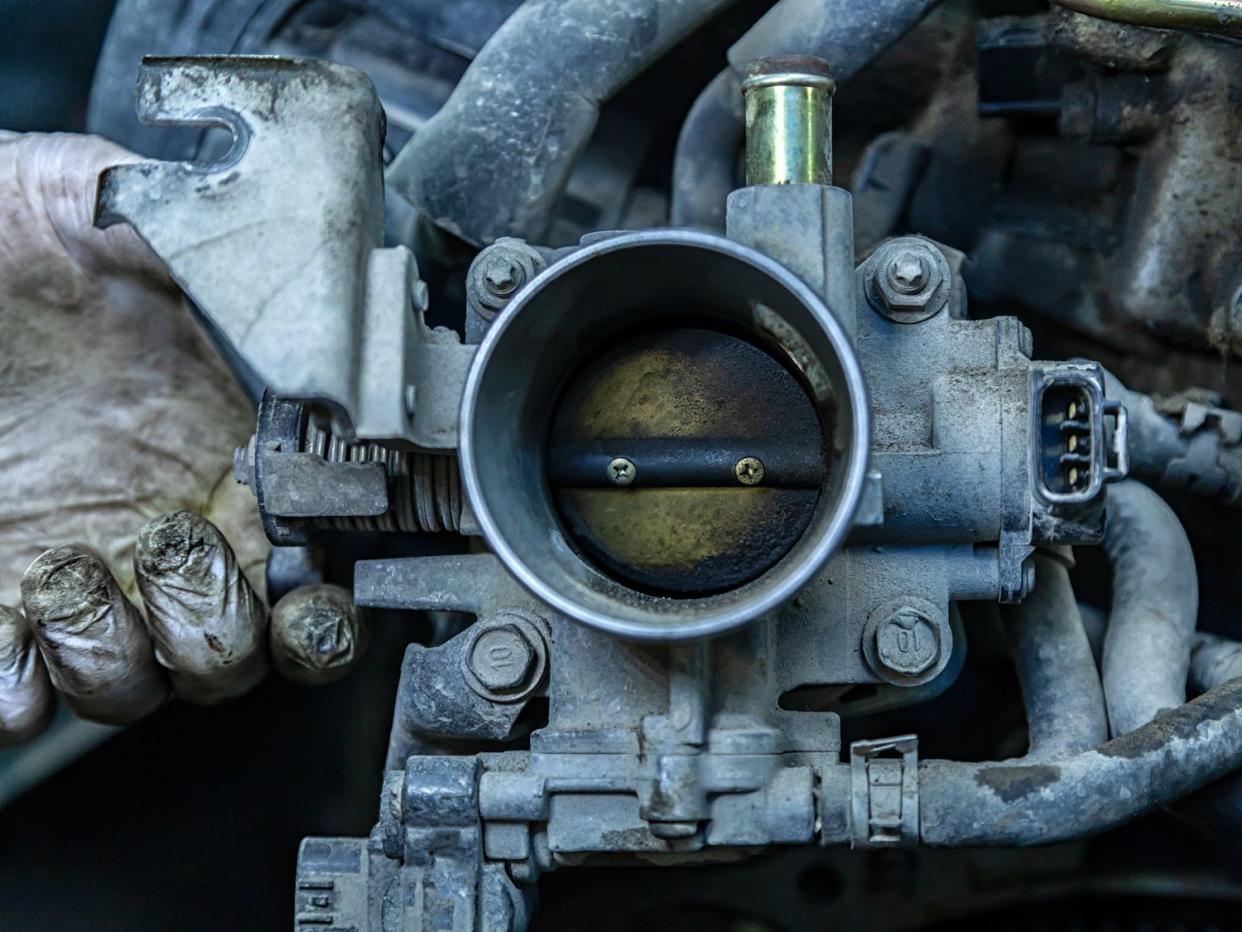 Close-up of the engine, throttle, raditor. Engine breakdown: contaminated throttle of an old car