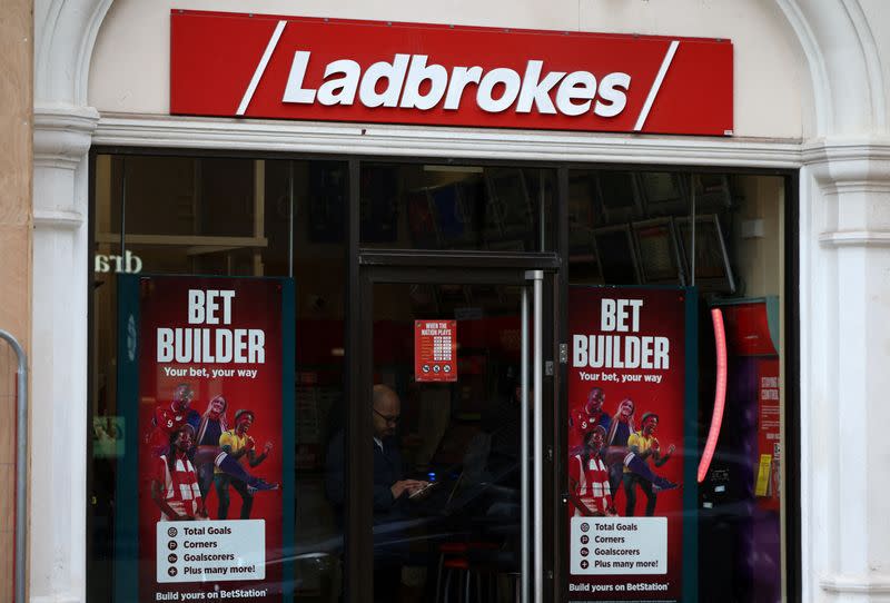 FILE PHOTO: A person stands inside a Ladbrokes betting shop in London