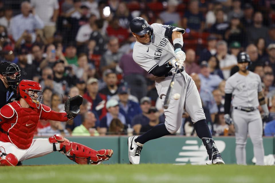 New York Yankees' Aaron Judge hits a grand slam next to Boston Red Sox catcher Reese McGuire during the second inning during the second game of a baseball doubleheader in Boston, Thursday, Sept. 14, 2023. (AP Photo/Michael Dwyer)