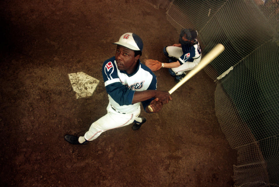 FILE- In this March 1974 file photo, Atlanta Braves outfielder Hank Aaron swings a bat at home plate during spring training. Hank Aaron, who endured racist threats with stoic dignity during his pursuit of Babe Ruth but went on to break the career home run record in the pre-steroids era, died early Friday, Jan. 22, 2021. He was 86. The Atlanta Braves said Aaron died peacefully in his sleep. No cause of death was given. (AP Photo, File)