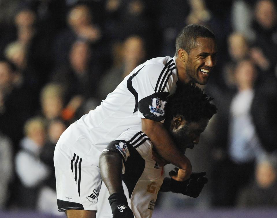 Swansea City's Wilfried Bony (R) celebrates scoring his second goal with Wayne Routledge, against Stoke City during their English Premier League soccer match at the Liberty Stadium in Swansea, Wales, November 10, 2013.