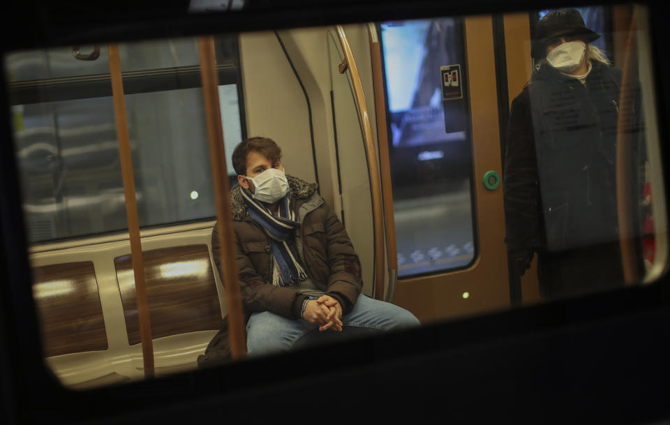 People wearing face masks travel by metro in Brussels, Wednesday, March 18, 2020. Belgium has ordered further lockdown measures starting Wednesday, following in the steps of European neighbours Italy, Spain and France. For most people, the new coronavirus causes only mild or moderate symptoms, such as fever and cough. For some, especially older adults and people with existing health problems, it can cause more severe illness, including pneumonia. (AP Photo/Francisco Seco)