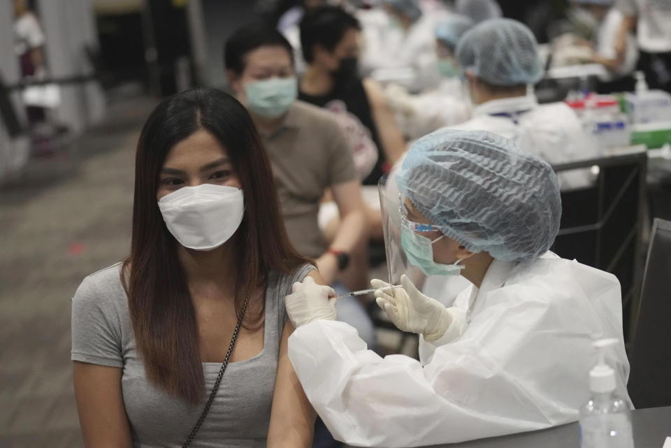 A health worker administers a dose of the AstraZeneca COVID-19 vaccine to a woman at Paragon shopping mall in Bangkok, Thailand, Monday, June 7, 2021. Health authorities in Thailand on Monday began their much-anticipated mass rollout of locally produced AstraZeneca vaccine, but it appeared that supplies were falling short of demand from patients who had scheduled vaccinations for this week. (AP Photo/Sakchai Lalit)