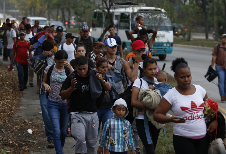 FILE - In this April 10, 2019 file photo, migrants walk at dawn as part of a new caravan of several hundred people sets off in hopes of reaching the distant United States, in San Pedro Sula, Honduras. "A situation of insecurity moves people," said National Human Rights Commissioner Roberto Herrera Cáceres. "It forces internal displacement that later turns into forced migrations." (AP Photo/Delmer Martinez, File)