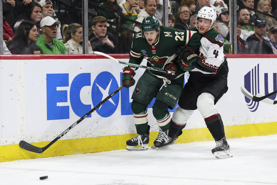 Minnesota Wild center Marco Rossi, left, and Arizona Coyotes defenseman Juuso Valimaki (4) compete for the puck during the first period of an NHL hockey game Tuesday, March 12, 2024, in St. Paul, Minn. (AP Photo/Matt Krohn)