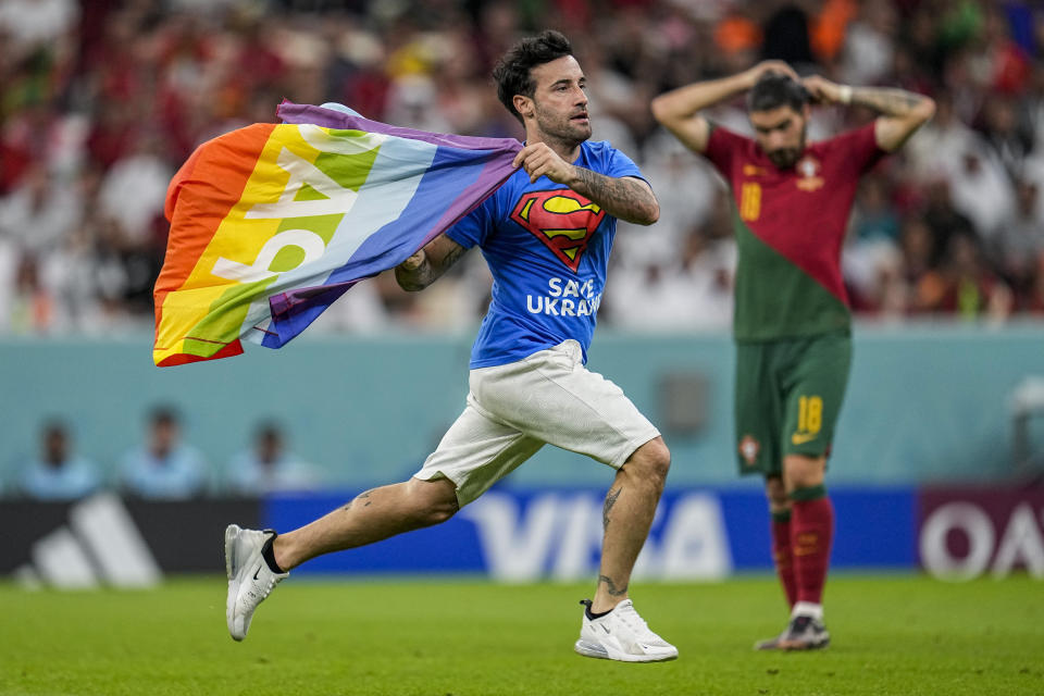 FILE - A pitch invader runs across the field with a rainbow flag during the World Cup group H soccer match between Portugal and Uruguay, at the Lusail Stadium in Lusail, Qatar, Monday, Nov. 28, 2022. (AP Photo/Abbie Parr, File)