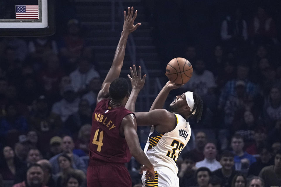 Indiana Pacers center Myles Turner (33) shoots as Cleveland Cavaliers forward Evan Mobley (4) defends during the first half of an NBA basketball game Saturday, Oct. 28, 2023, in Cleveland. (AP Photo/Sue Ogrocki)