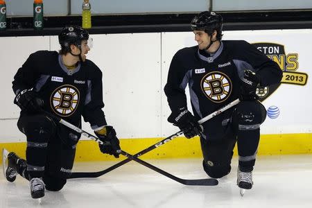 Boston Bruins defensemen David Warsofsky (L) Adam McQuaid stretch during practice ahead of the start of the NHL hockey season in Boston, Massachusetts January 15, 2013. REUTERS/Brian Snyder