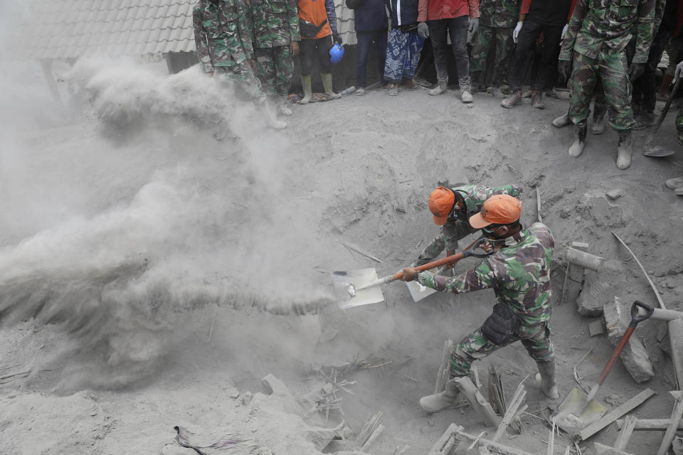 Soldiers search for victims in a location where a house is buried beneath volcanic ash from the eruption of Mount Semeru in Candi Pure village, Lumajang, East Java, Indonesia, Tuesday, Dec. 7, 2021. Indonesia's president on Tuesday visited areas devastated by the powerful volcanic eruption that killed a number of people and left thousands homeless, and vowed that communities would be quickly rebuilt. (AP Photo/Trisnadi)