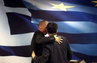 Newly-appointed Finance Minister Euclid Tsakalotos (R) and outgoing Yannis Varoufakis embrace at the Finance Ministry after a handover ceremony in Athens, Greece July 6, 2015. REUTERS/Yannis Behrakis