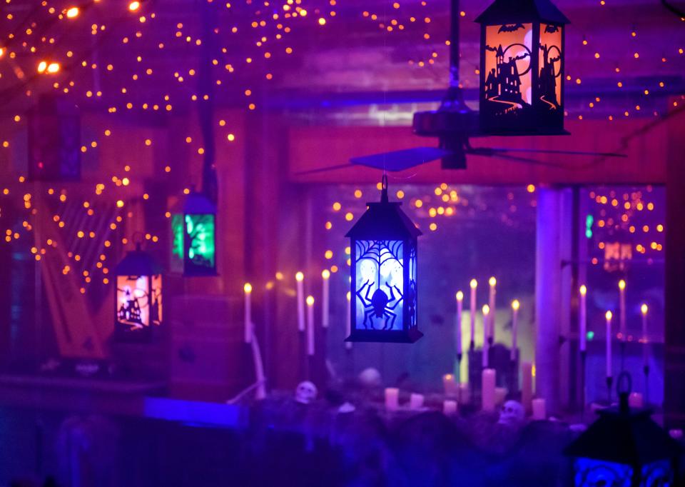 Colorful lanterns with haunted houses, spiders and other scary silhouettes hang from the rafters of Kelleher's Irish Pub's Halloween-themed pop-up bar Cauldrons and Cocktails in Peoria.