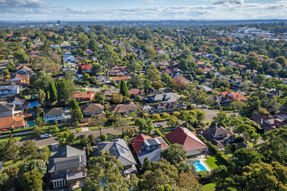 An aerial view of houses and property in an affluent, leafy suburb.