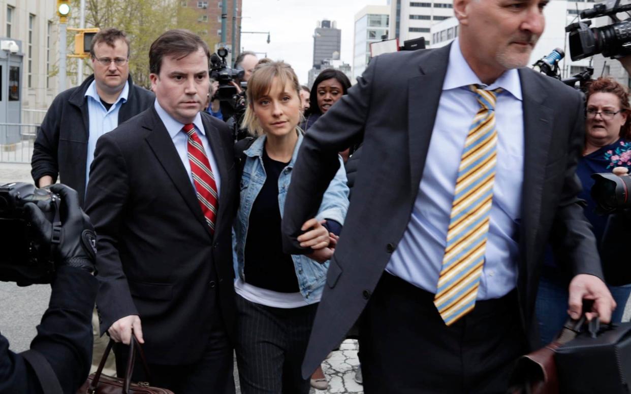 Allison Mack is escorted away from Federal court Tuesday, April 24, 2018, in Brooklyn, New York - AP