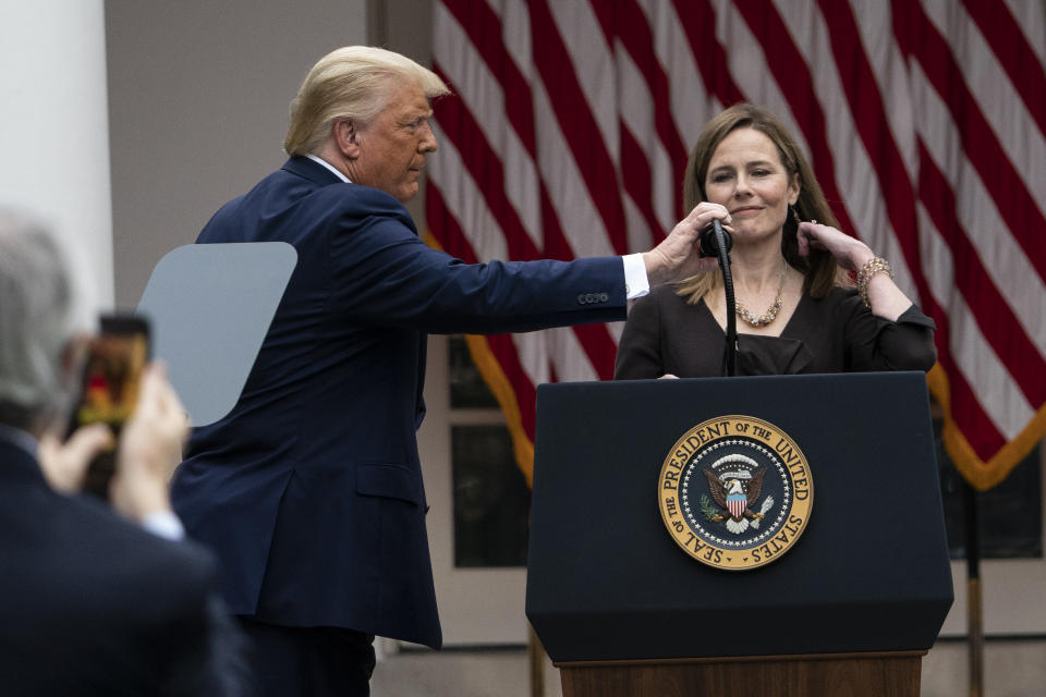 President Donald Trump adjusts the microphone after he announced Judge Amy Coney Barrett as his nominee to the Supreme Court, in the Rose Garden at the White House, Saturday, Sept. 26, 2020, in Washington. (AP Photo/Alex Brandon)