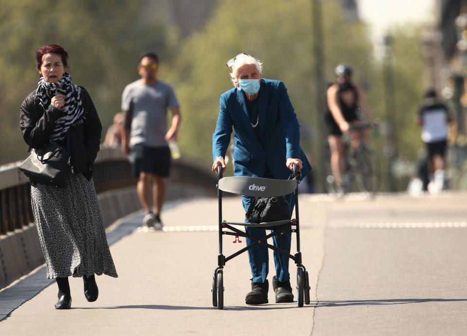 An elderly woman wearing a face mask and using a walker on Westminster Bridge, London, as the UK continues in lockdown to help curb the spread of the coronavirus.