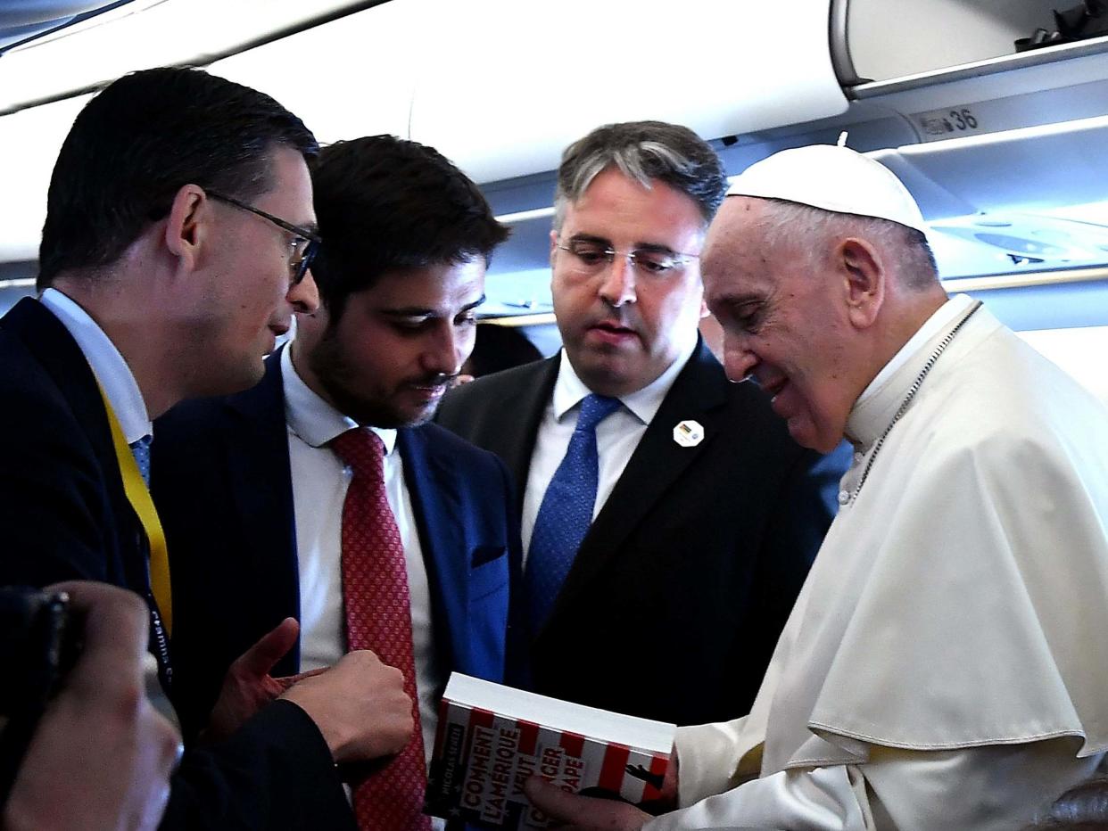 Pope Francis holds the book 'How America Wanted to Change the Pope' on board of the plane on the way to Mozambique: AFP/Getty Images