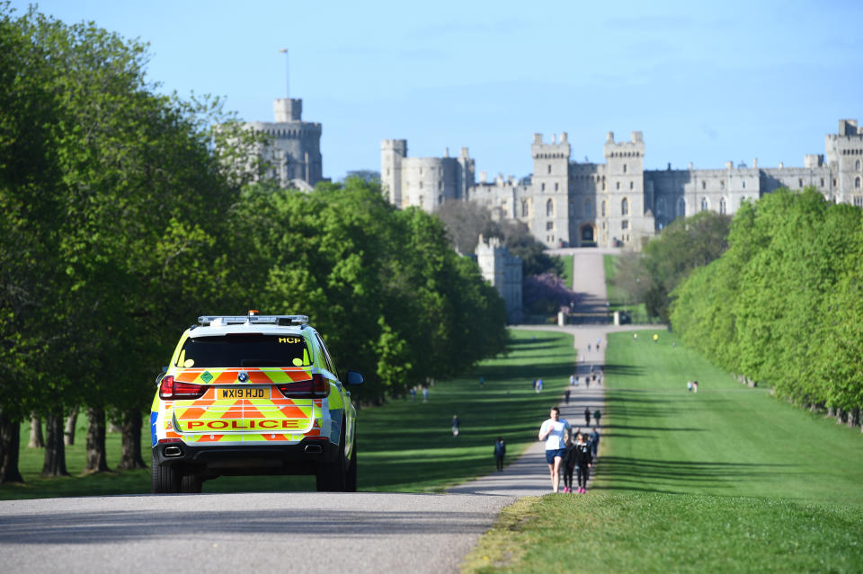 Police monitor people on the Long Walk in Windsor, as the UK continues in lockdown to help curb the spread of the coronavirus.