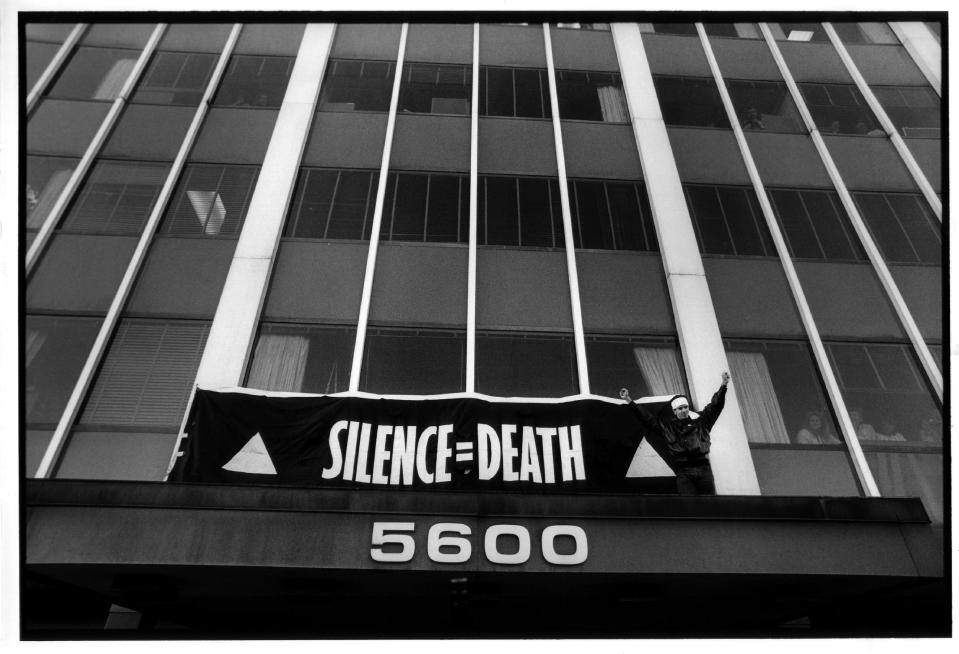 This Oct. 11, 1988 publicity photo released by Sundance Selects shows Peter Staley in a scene from director, David France’s documentary film, "How to Survive a Plague," a Sundance Selects release. Staley triumphantly finishes hanging a banner over the entrance to the FDA main headquarters, during an HIV AIDS civil disobedience demonstration, in Rockville, Md. (AP Photo/Sundance Selects, Rick Reinhard)